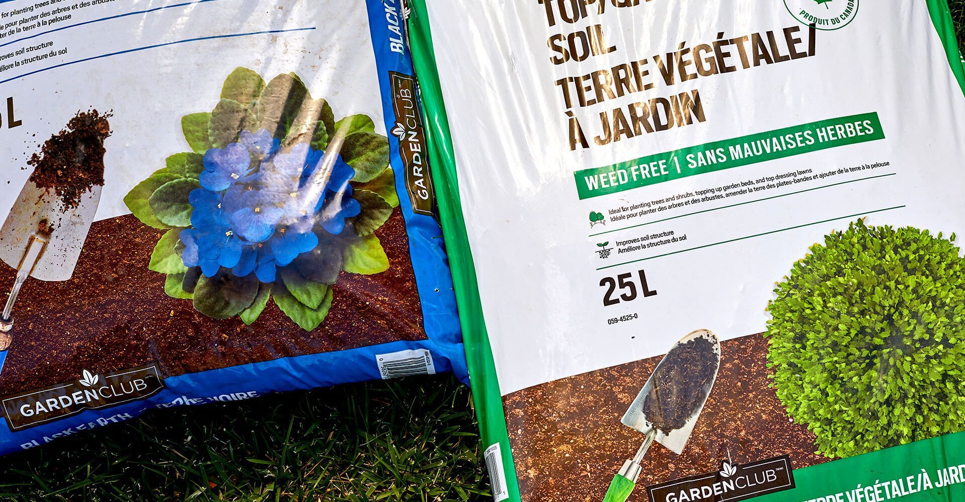 Two bags of soil are sitting next to each other on the grass.
