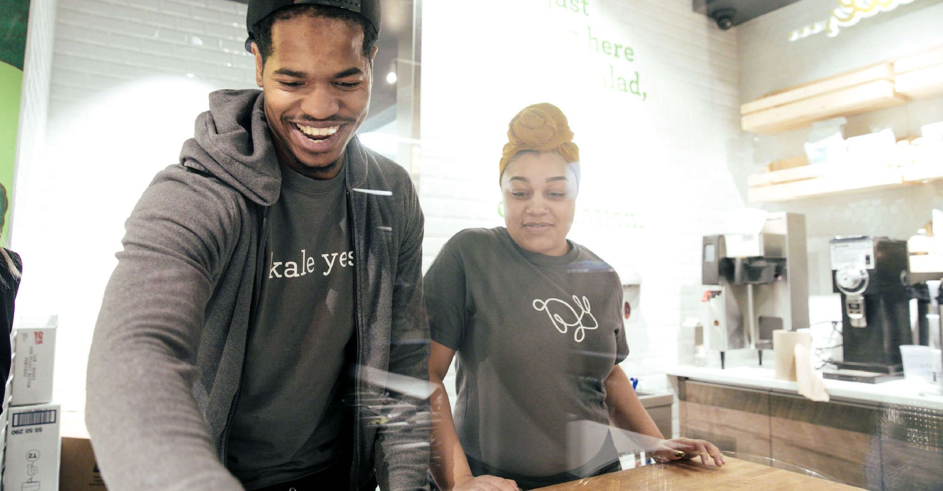 A man and a woman are standing next to each other in a restaurant.