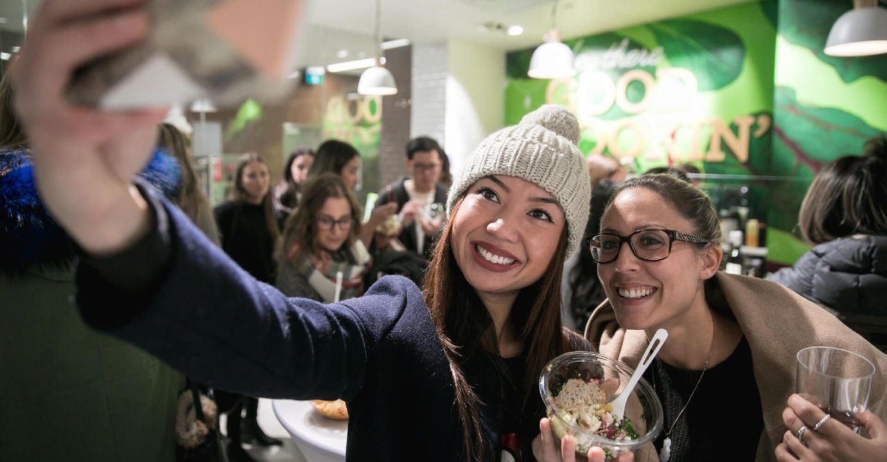 Two women are taking a selfie in a restaurant.
