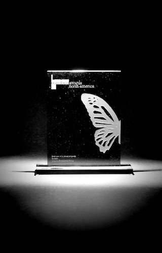 A black and white photo of a glass plaque with a butterfly on it.