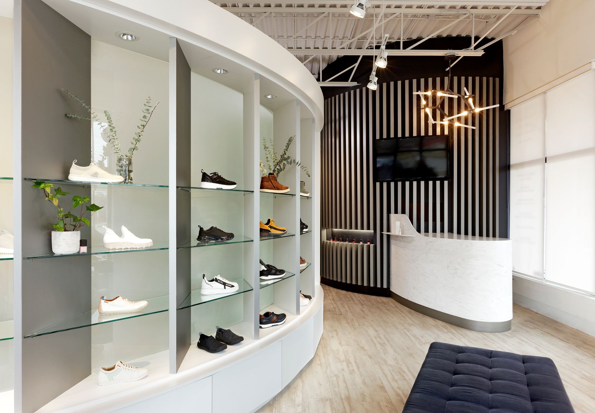 A man is sitting on a bench in a shoe store.