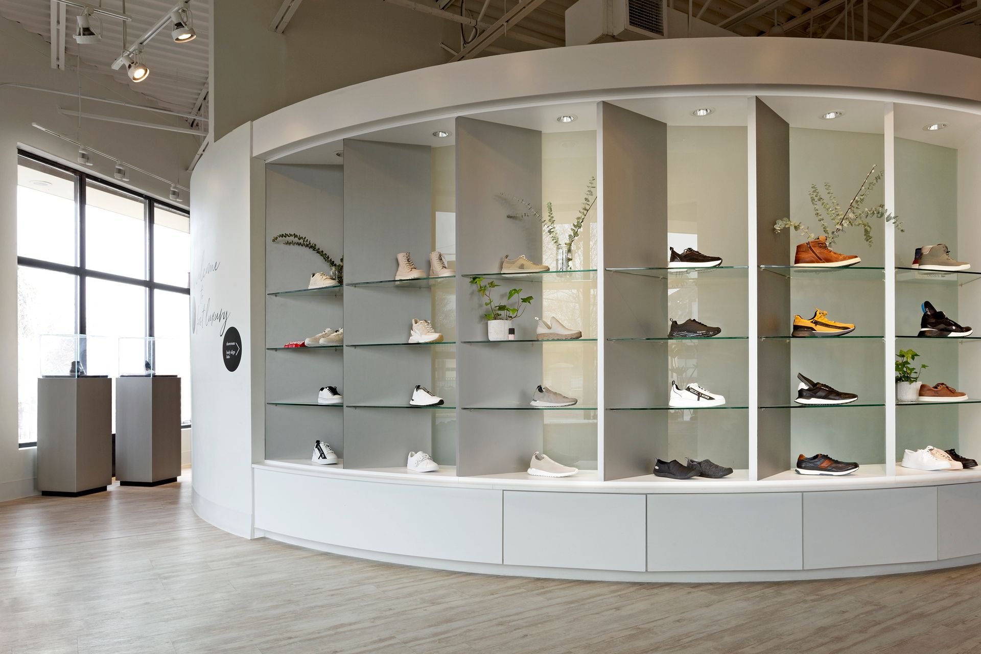A man and woman are sitting on a bench in a shoe store.