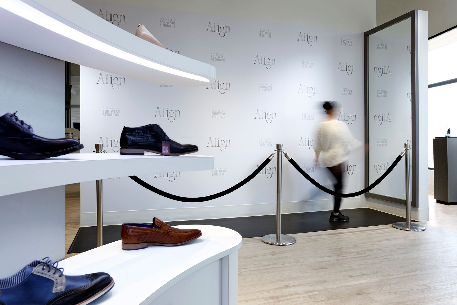 A blurred image of a person walking in a shoe store