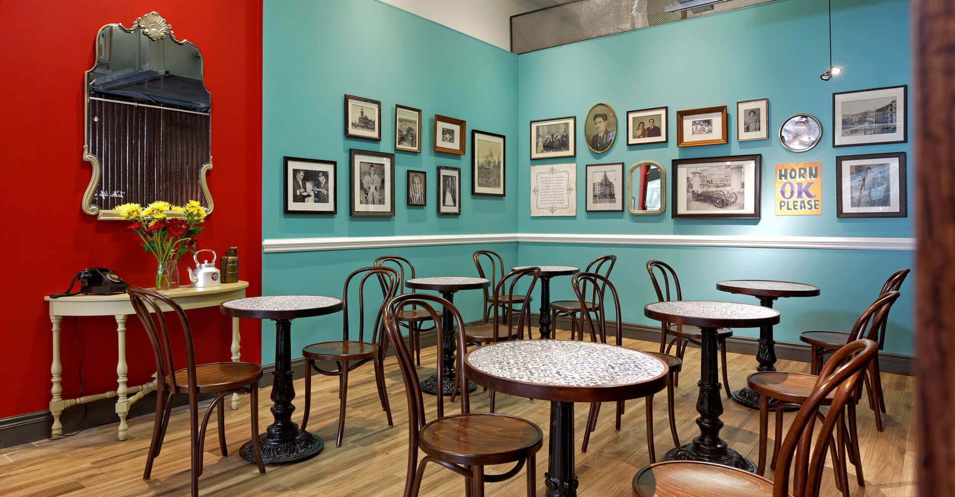 A room with tables and chairs and pictures on the wall.