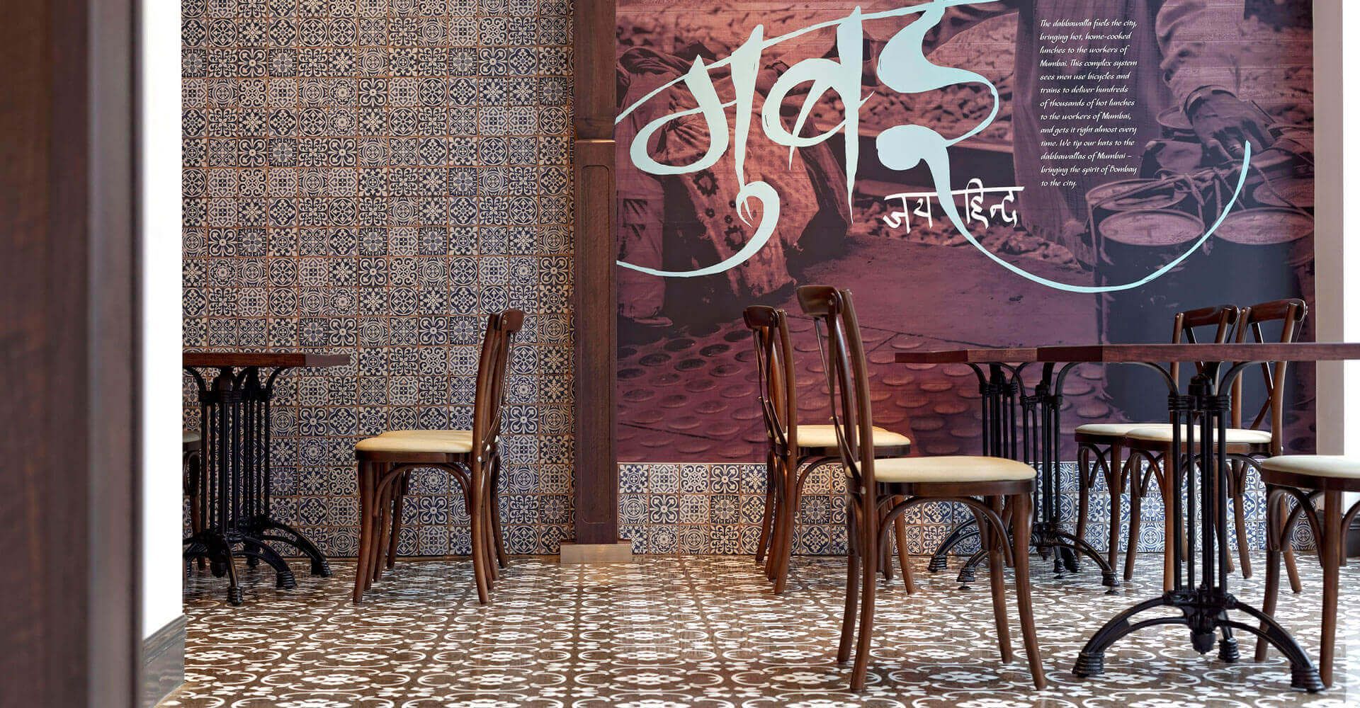 A restaurant with tables and chairs and a wall with a picture on it.