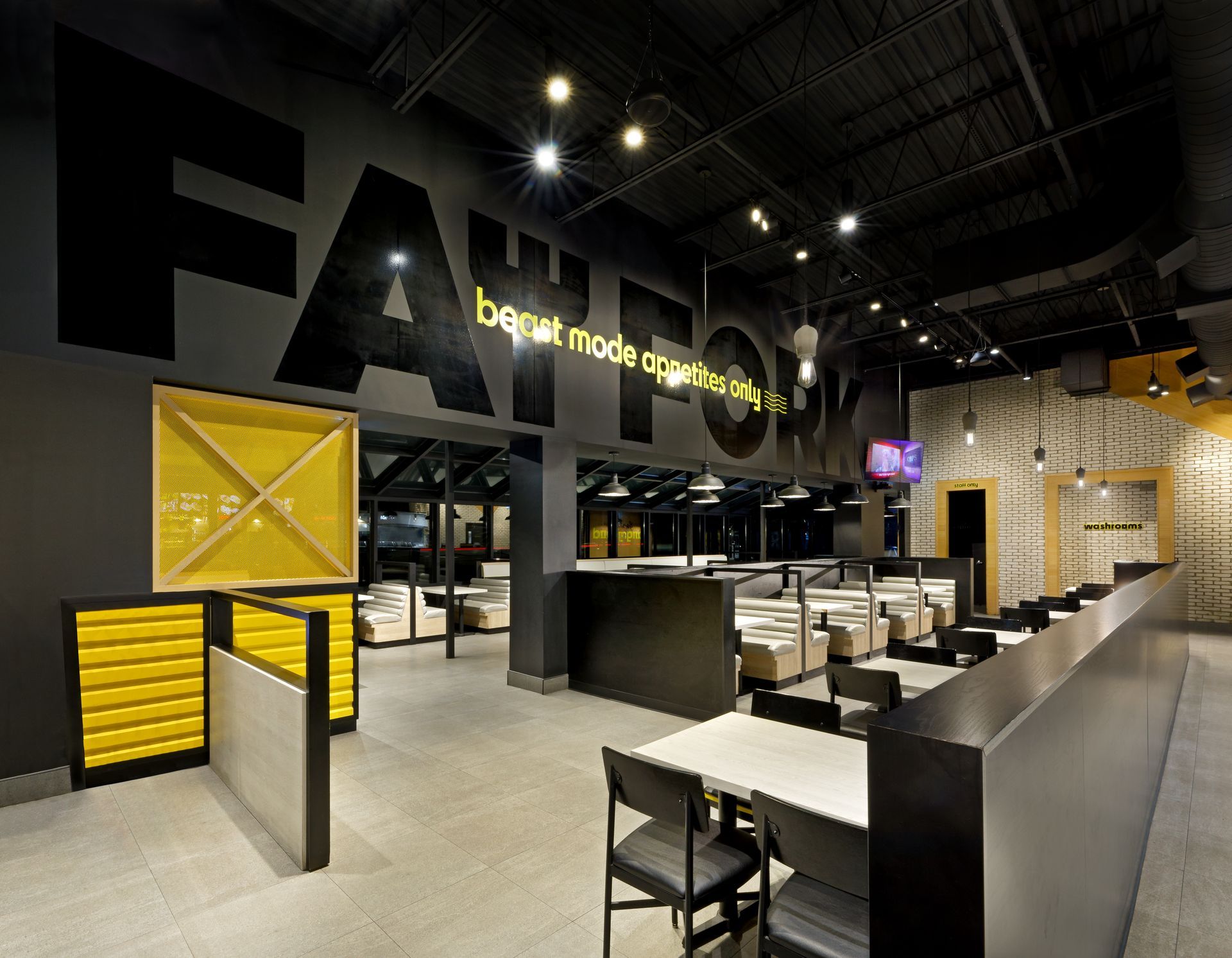 A restaurant with tables and chairs and a sign that says fattom