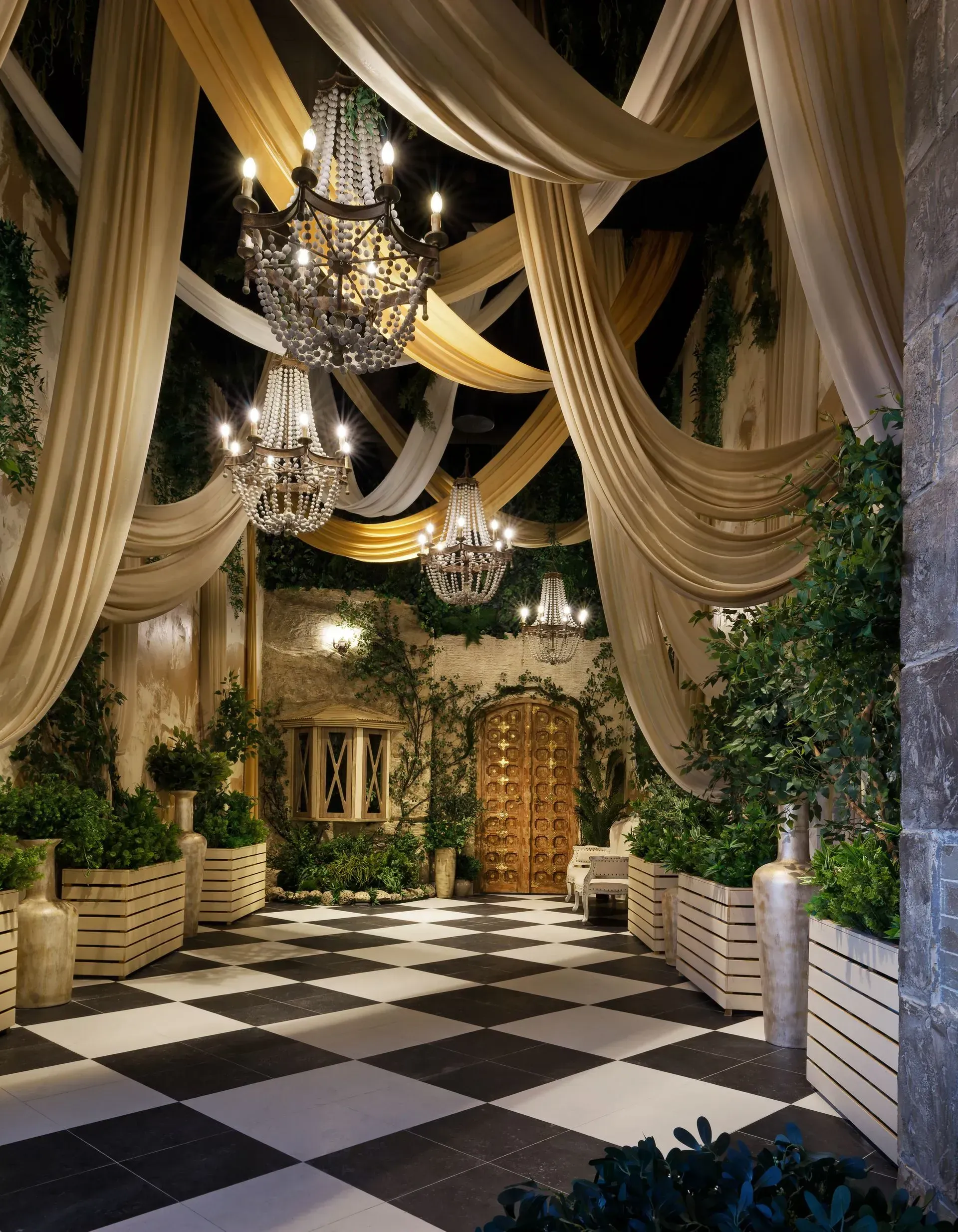 A room with a checkered floor and chandeliers hanging from the ceiling