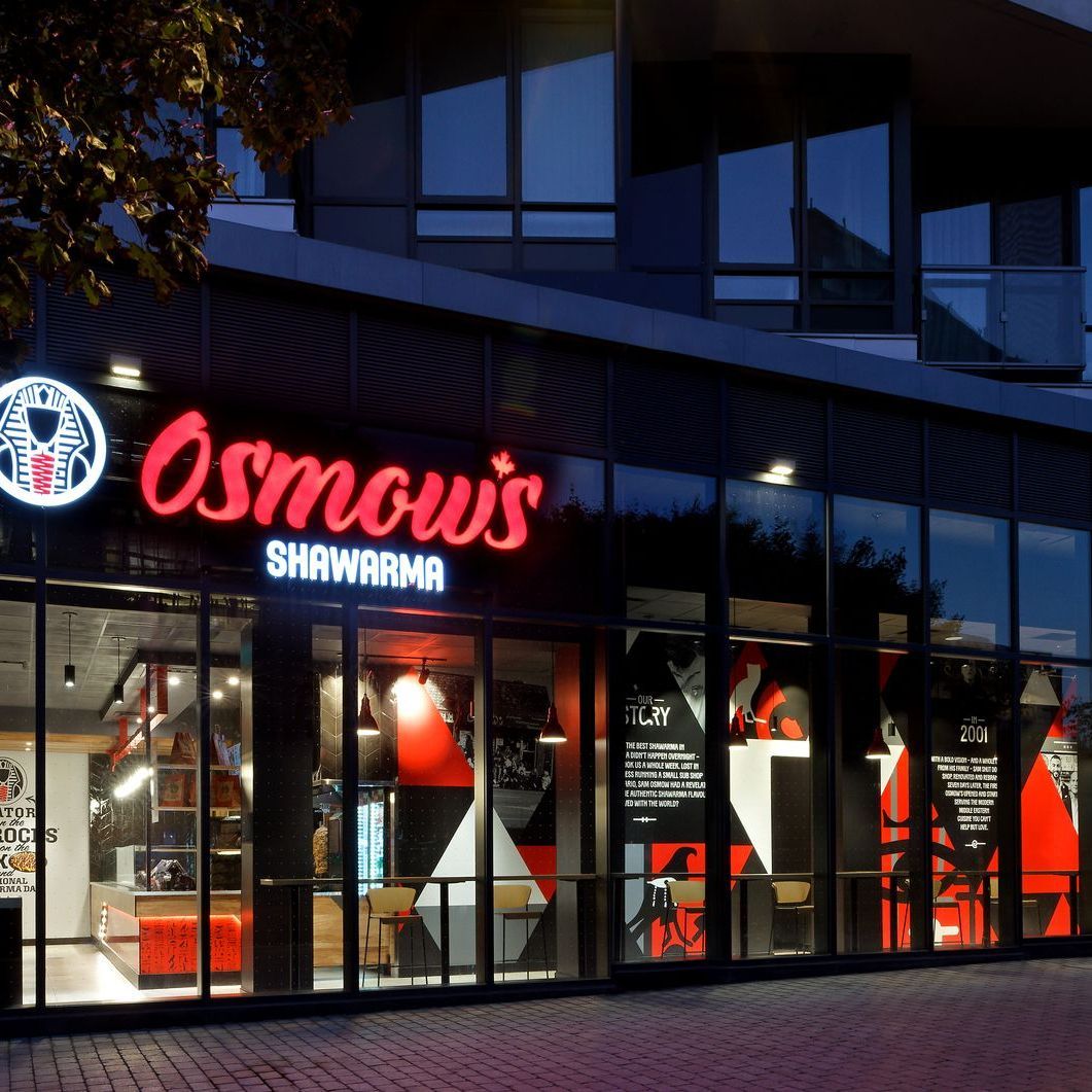 A restaurant called osnow 's shawarma is lit up at night