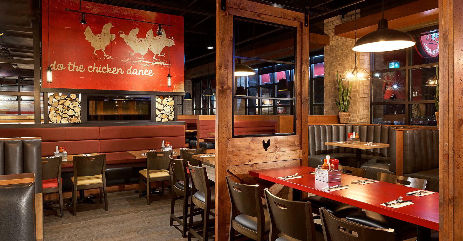 A restaurant with tables and chairs and a sign that says ' chicken ' on it