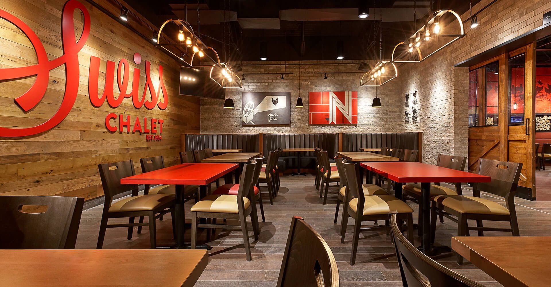 A restaurant filled with tables and chairs with a sign on the wall that says chili 's.