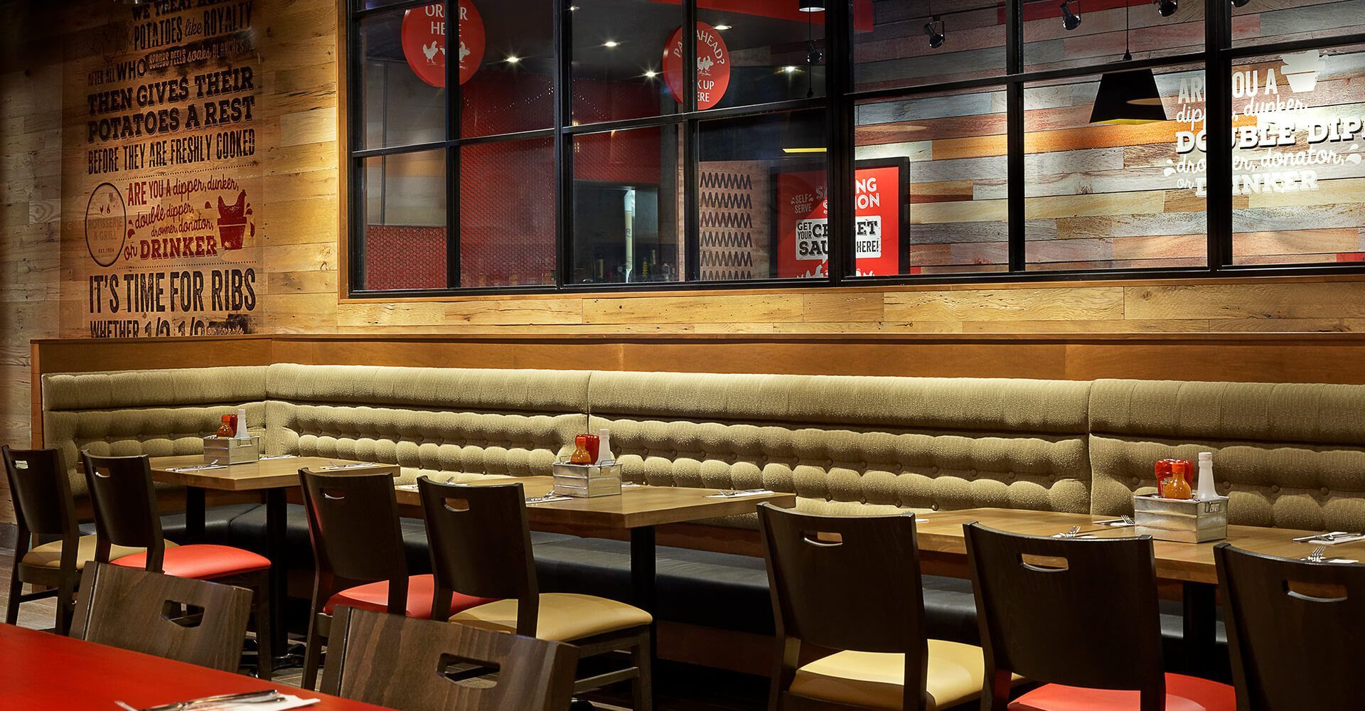 A restaurant with tables and chairs and a brick wall.