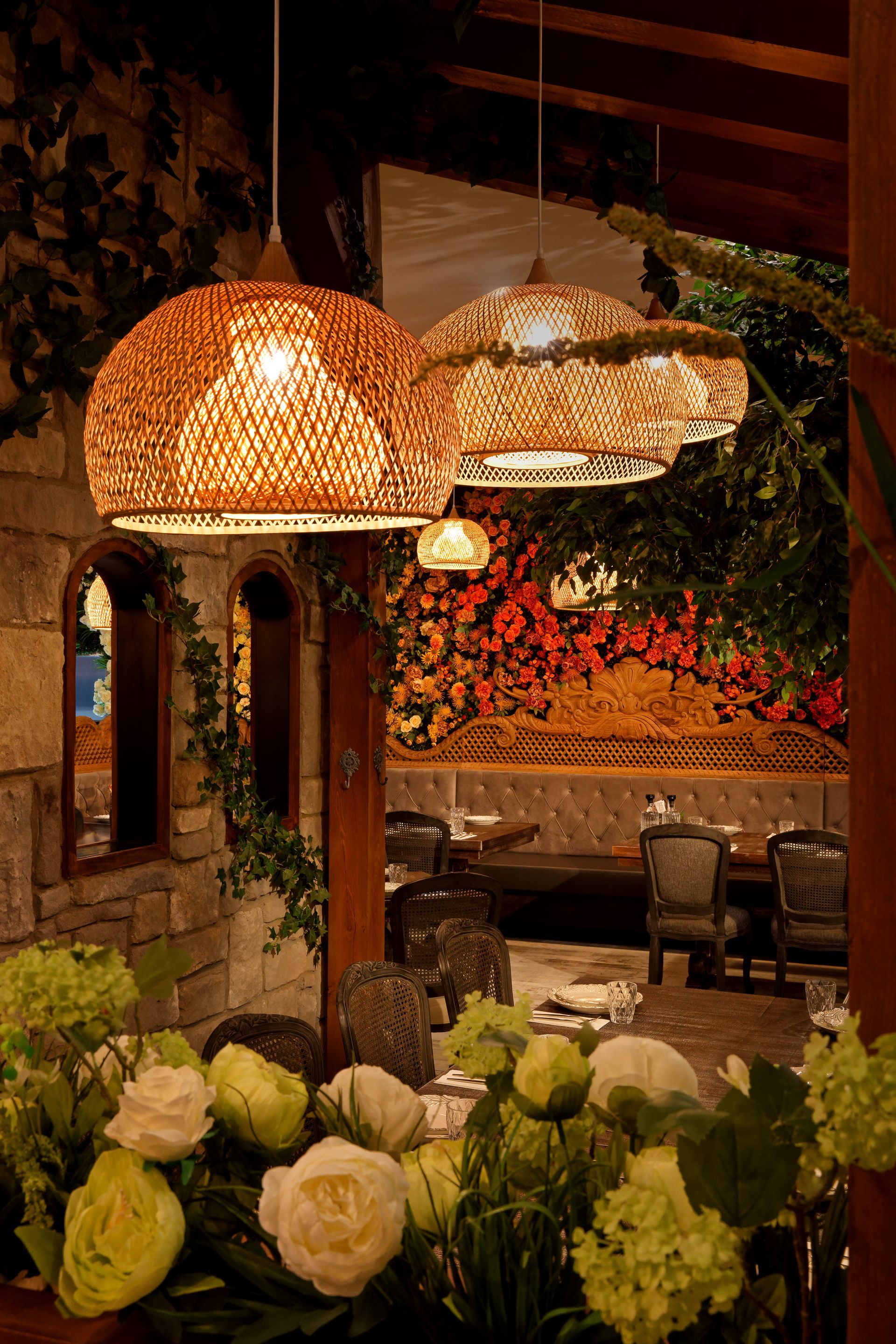 A restaurant with lots of tables and chairs and flowers on the table