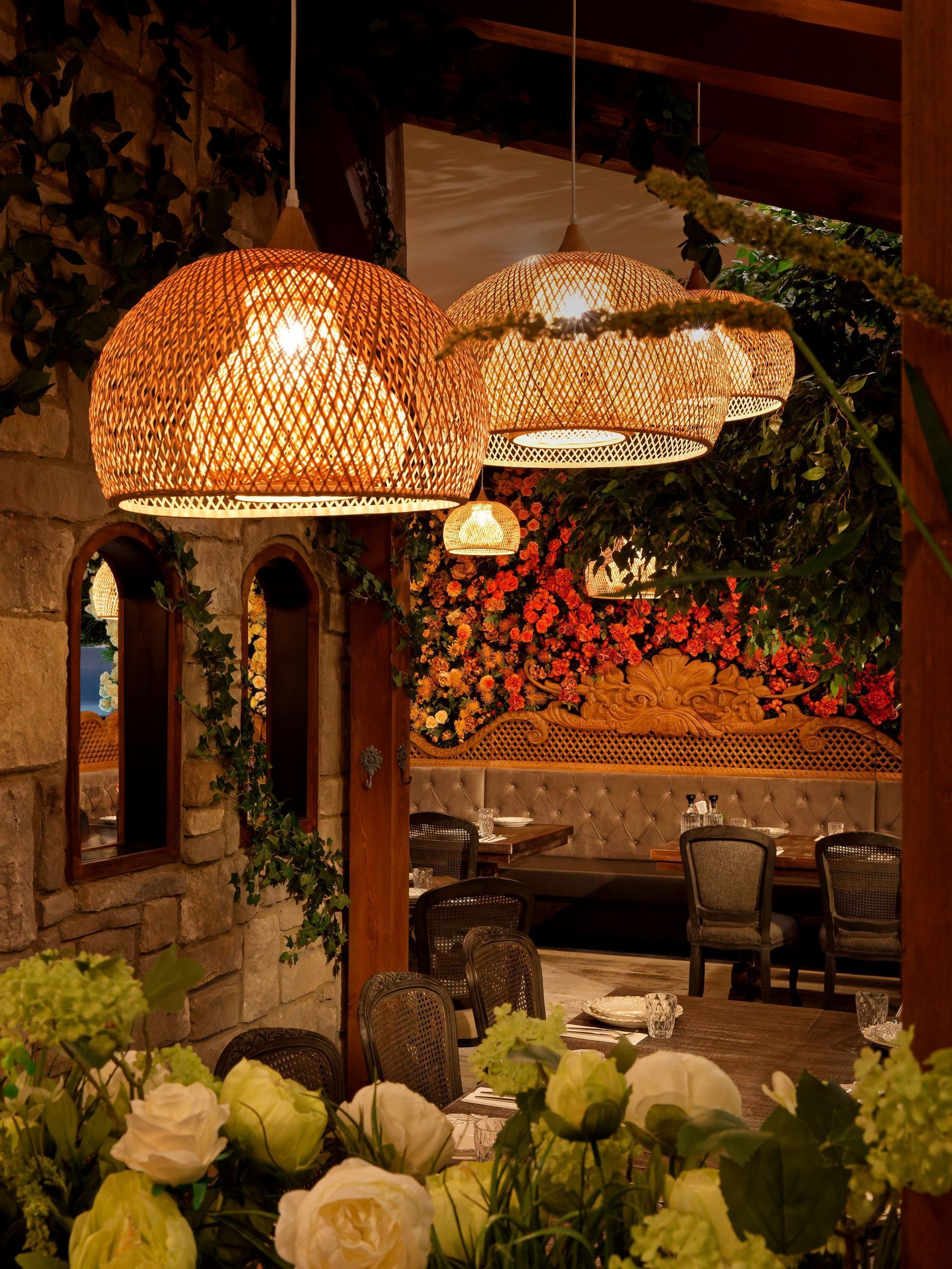 A restaurant with a lot of tables and chairs and flowers on the table