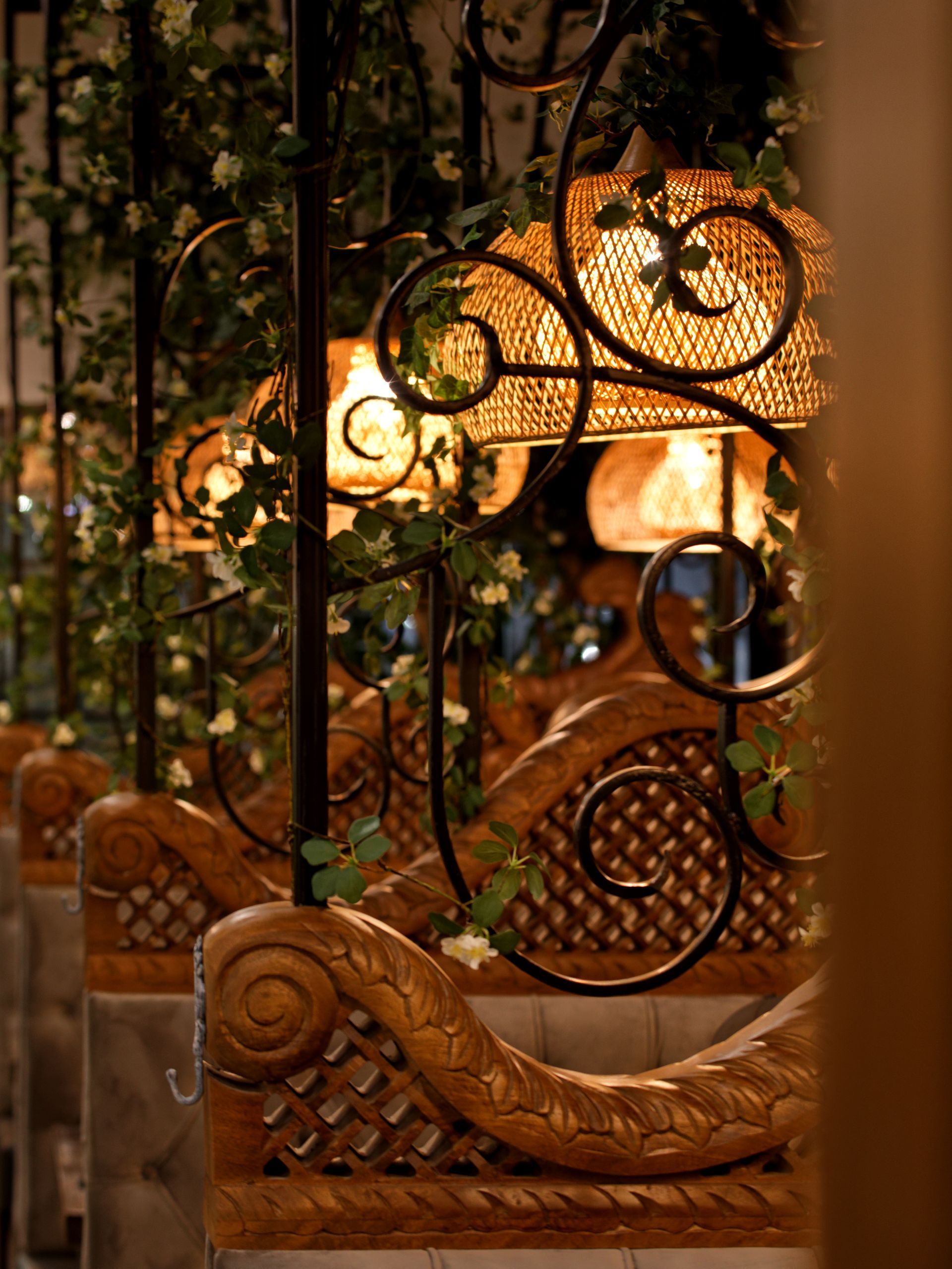 A row of wooden benches with a wrought iron railing in a restaurant.