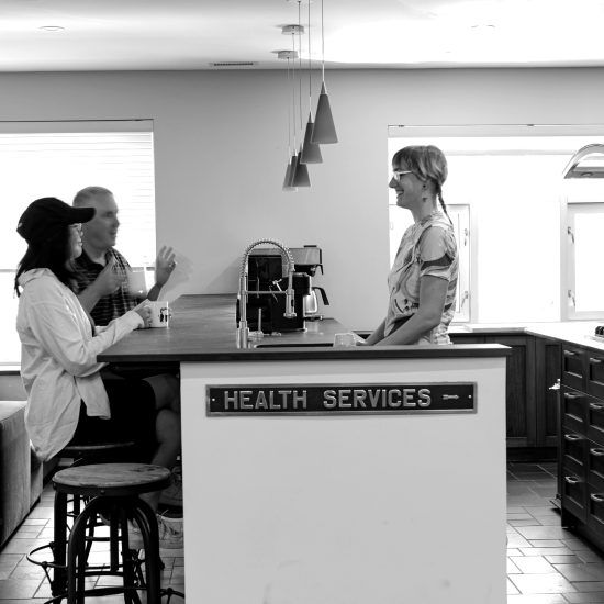 A black and white photo of a kitchen with a sign that says health services