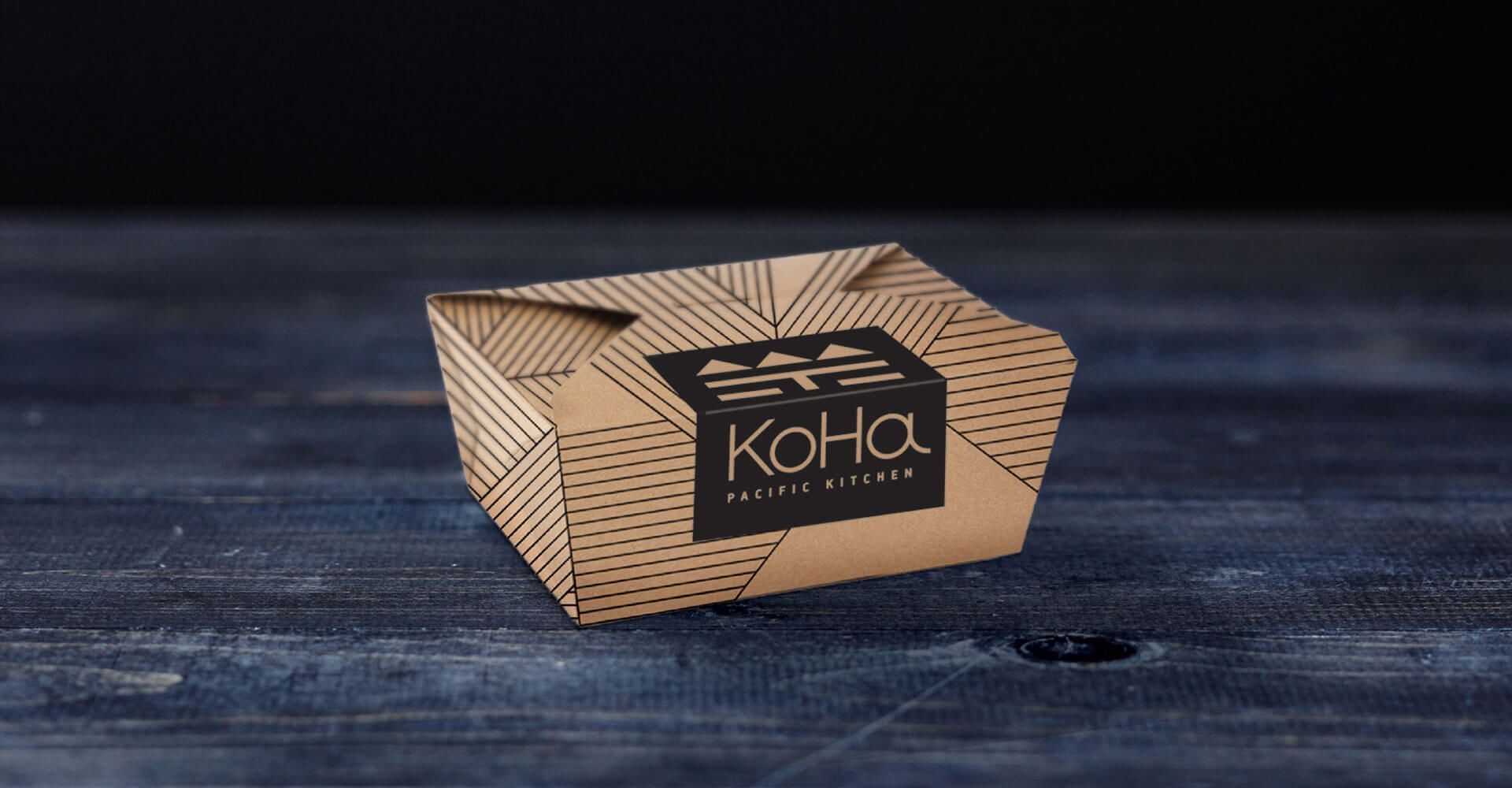 A brown box with the word koha on it is sitting on a wooden table.