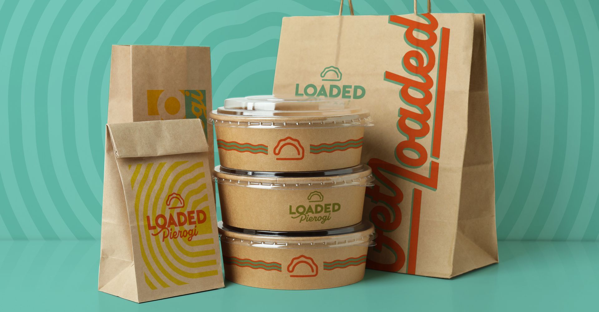 A stack of food containers sitting on top of a table next to a bag.