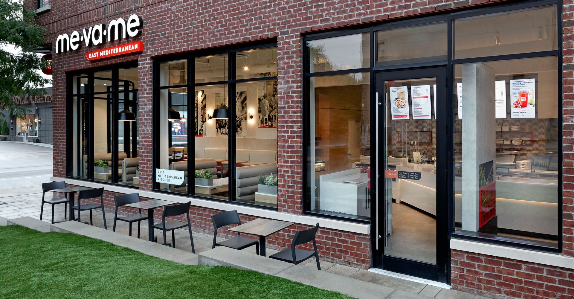A brick building with tables and chairs in front of it