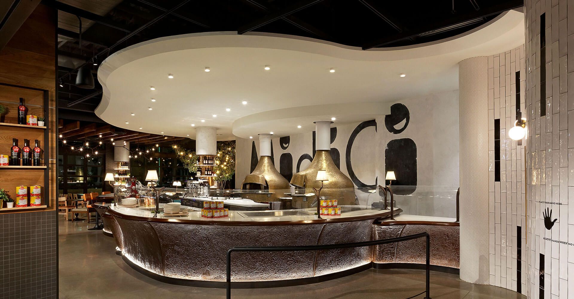 A restaurant with a long counter and a ceiling that looks like a wave.