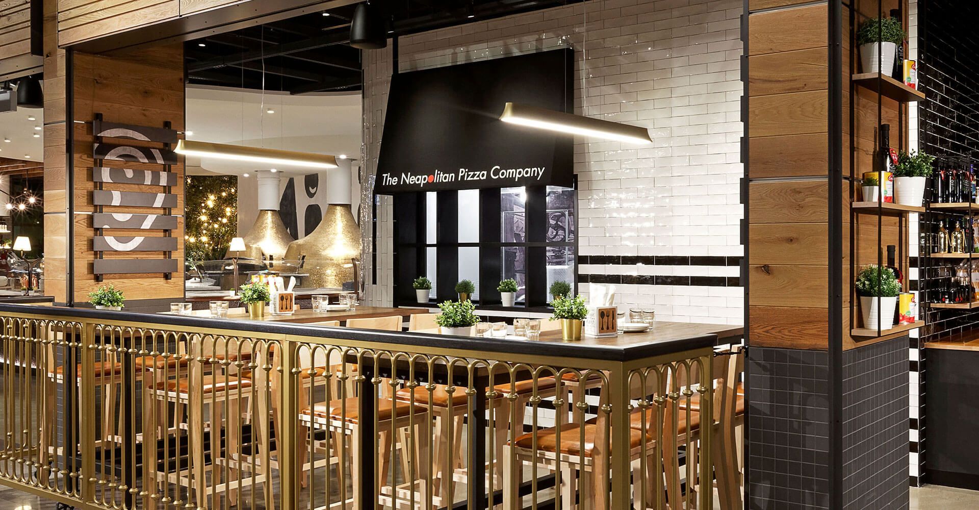 A restaurant with a long bar and tables and chairs.