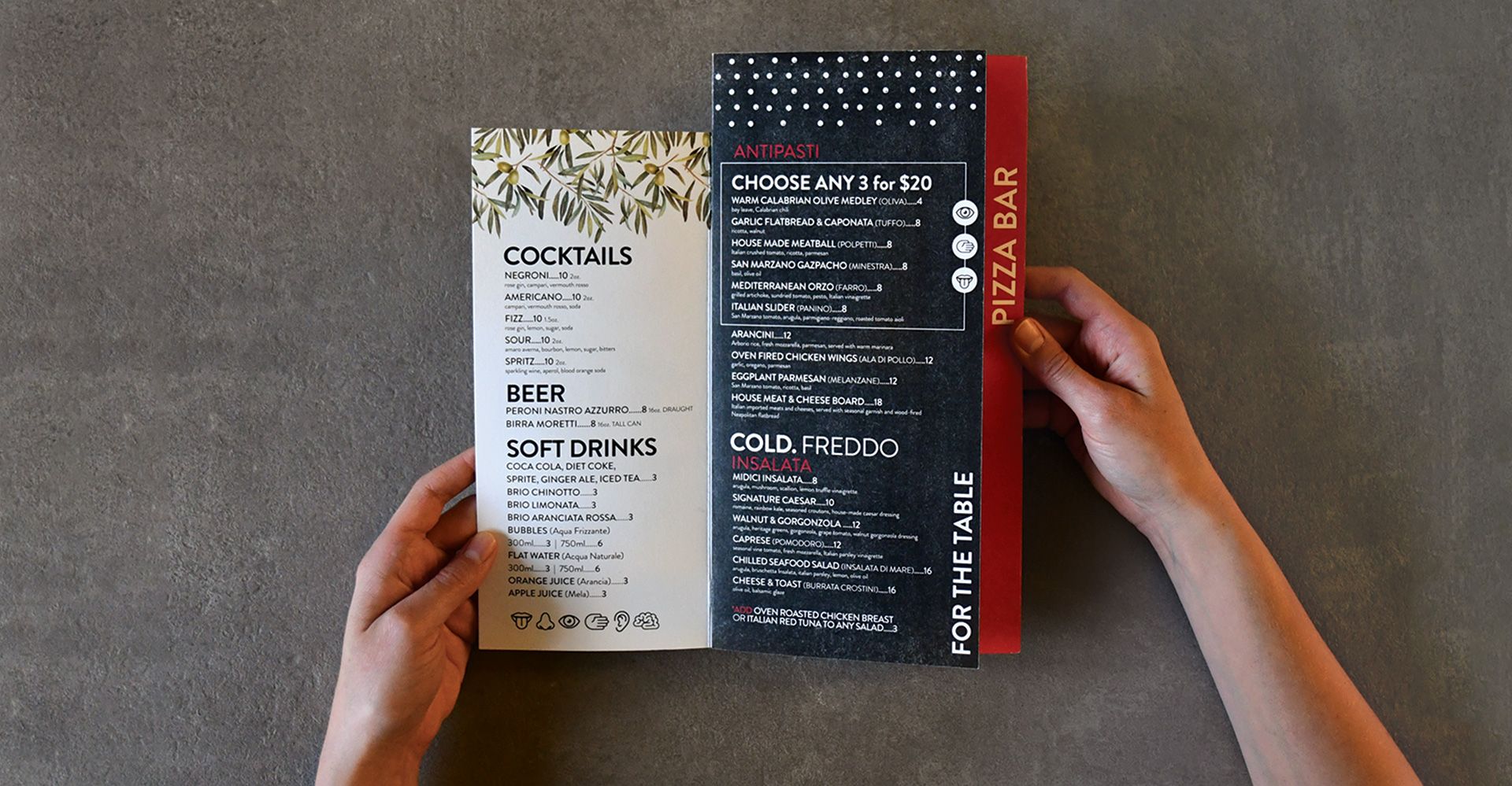 A person is holding a menu that says cocktails and pizza bar