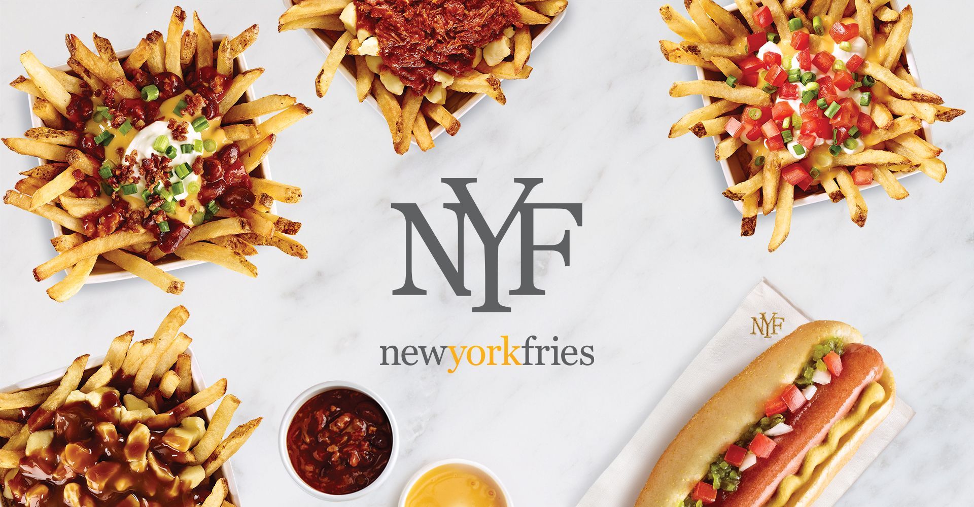 A variety of french fries and a hot dog are on a table.