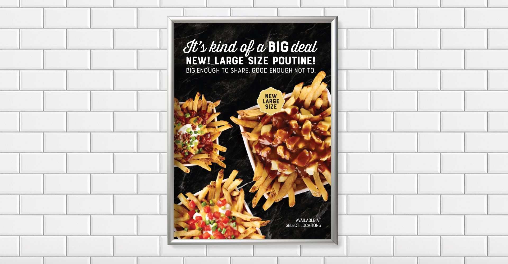 A pizza and french fries poster is hanging on a white brick wall.