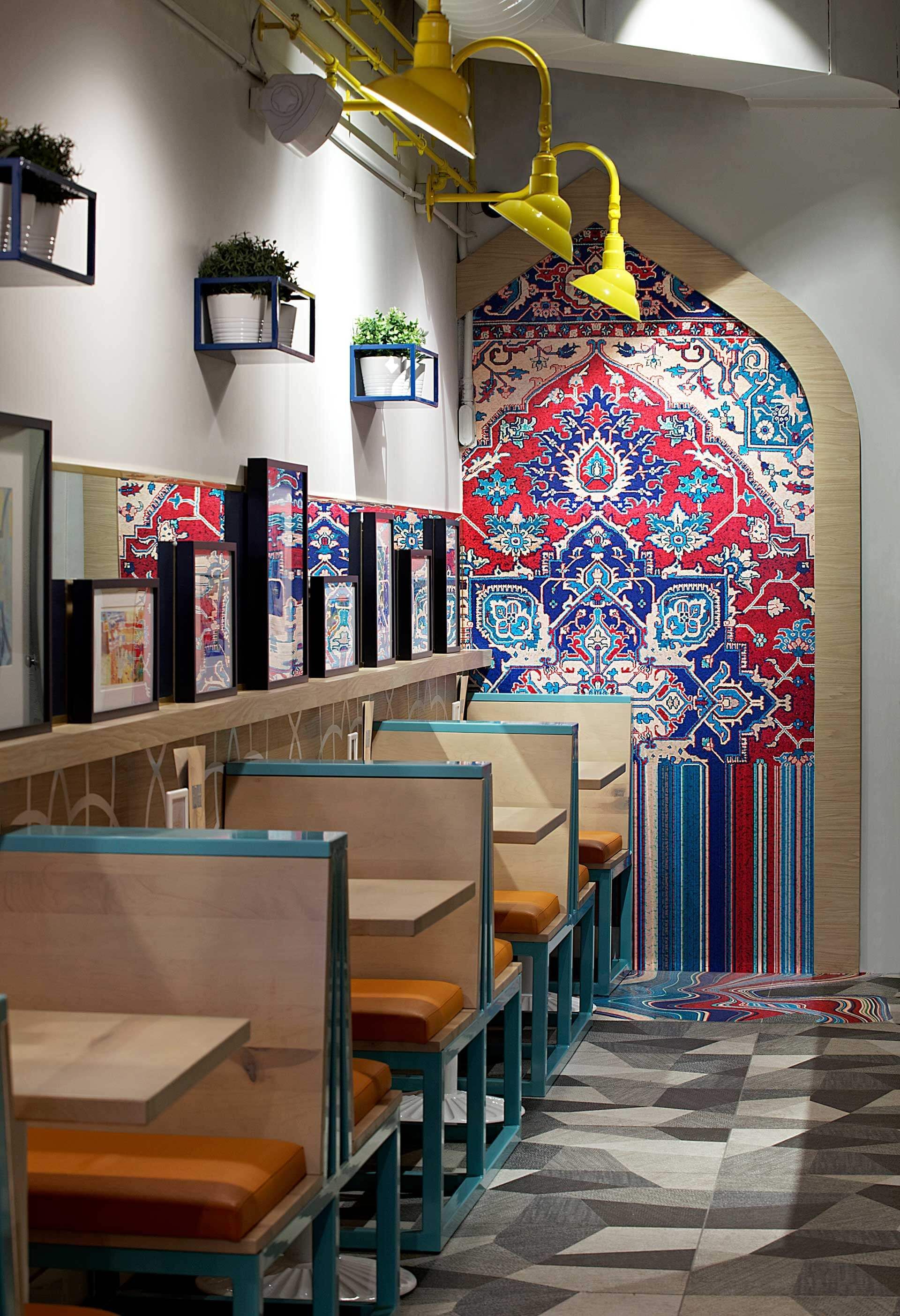 A restaurant with tables and chairs and a colorful wall