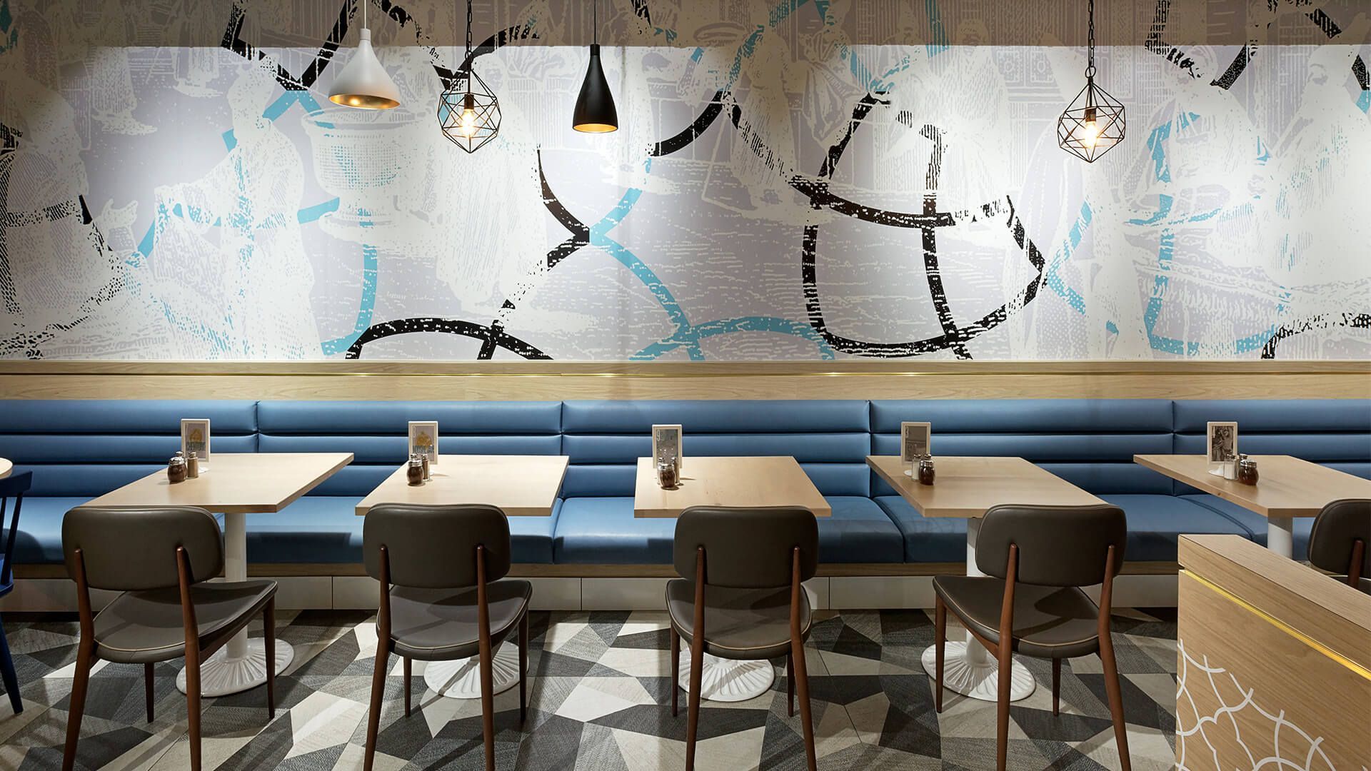 A restaurant with tables and chairs and a painting on the wall.