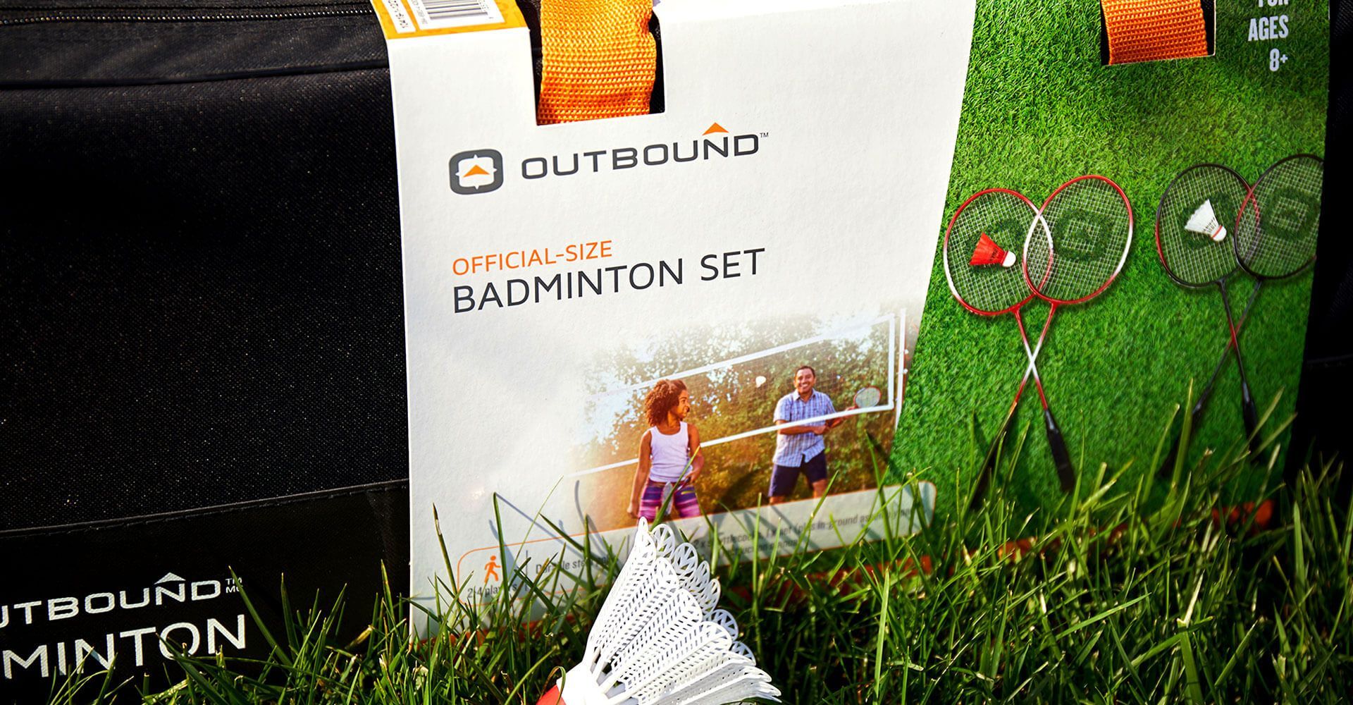 A badminton set is sitting on top of a lush green field.