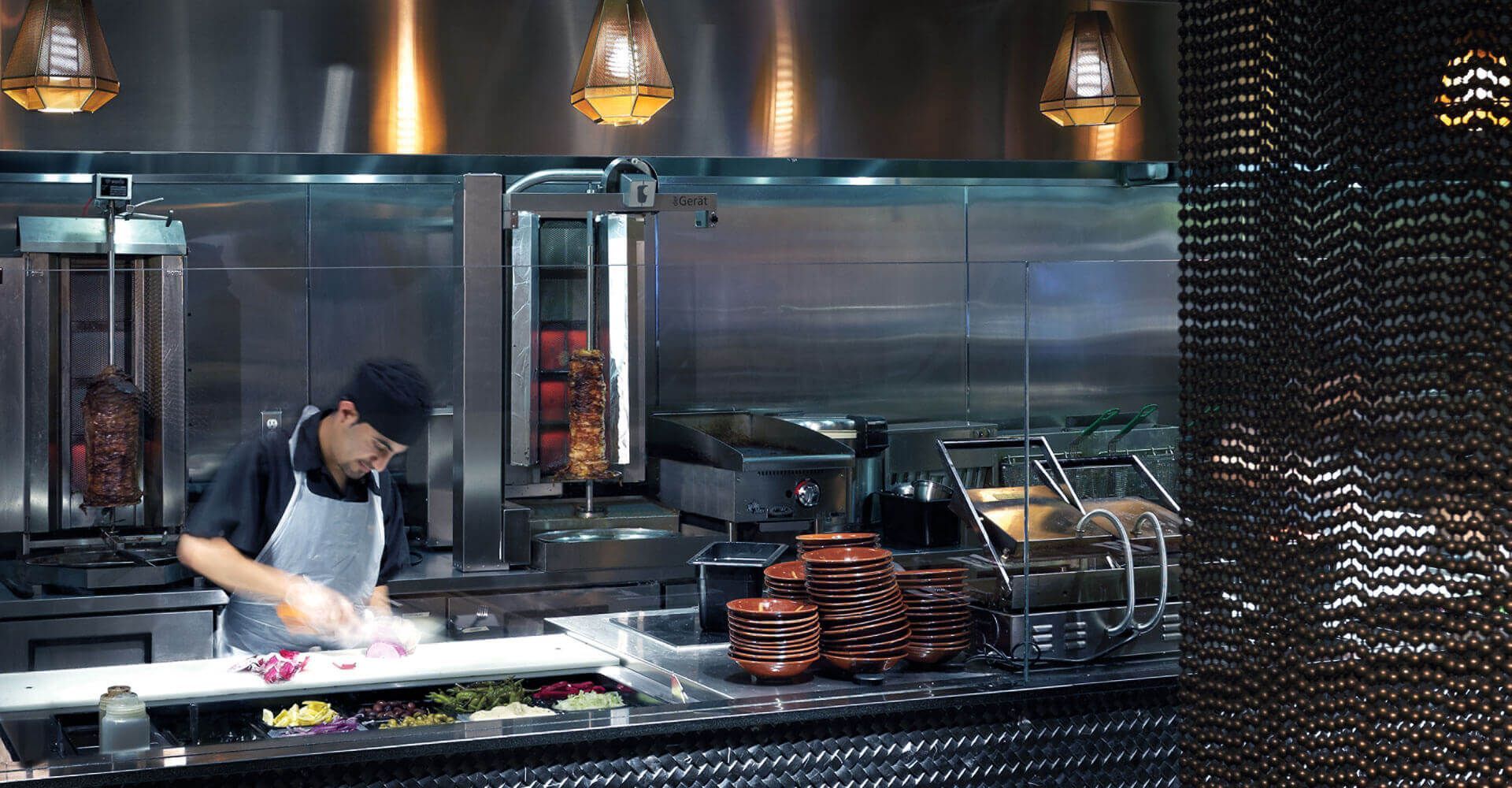 A man in an apron is preparing food in a kitchen