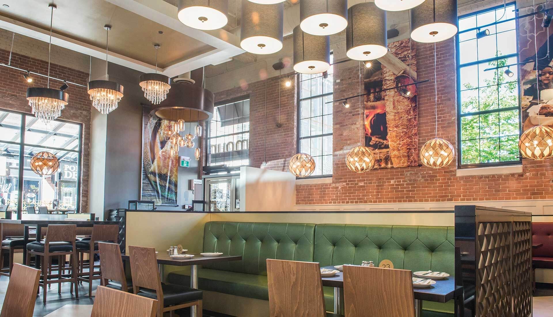 A restaurant with tables and chairs and a brick wall.