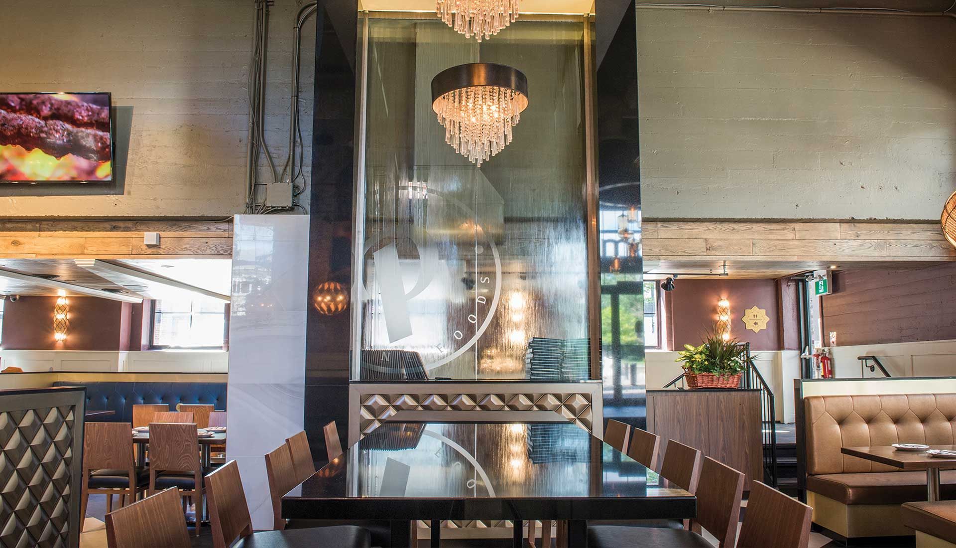 A restaurant with tables and chairs and a chandelier hanging from the ceiling.