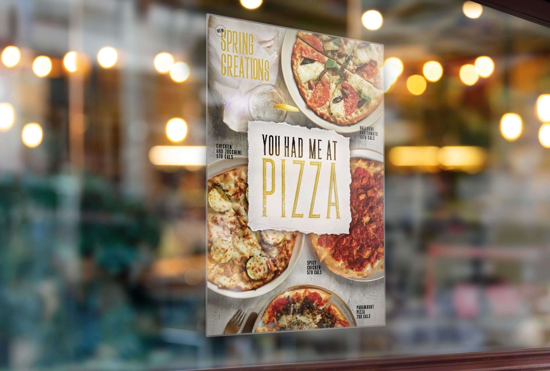 A pizza poster is hanging on a window in a restaurant.