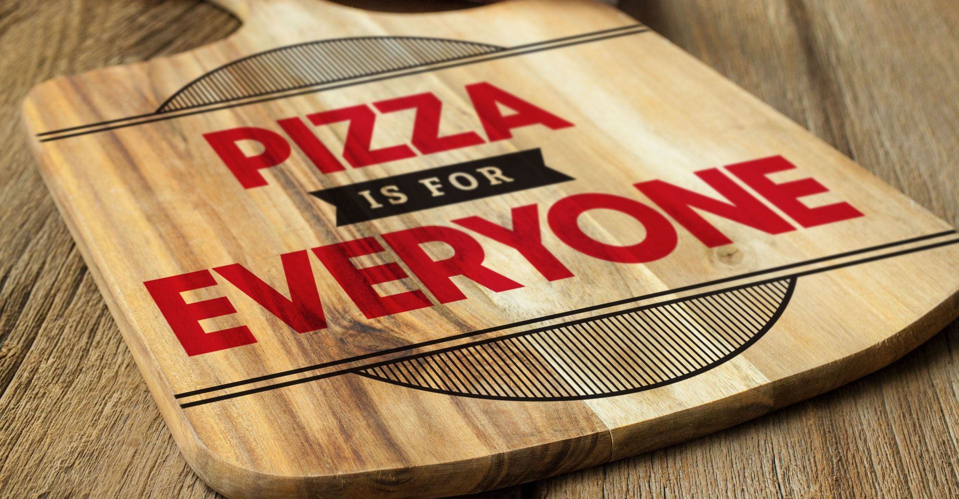 A wooden cutting board that says pizza is for everyone