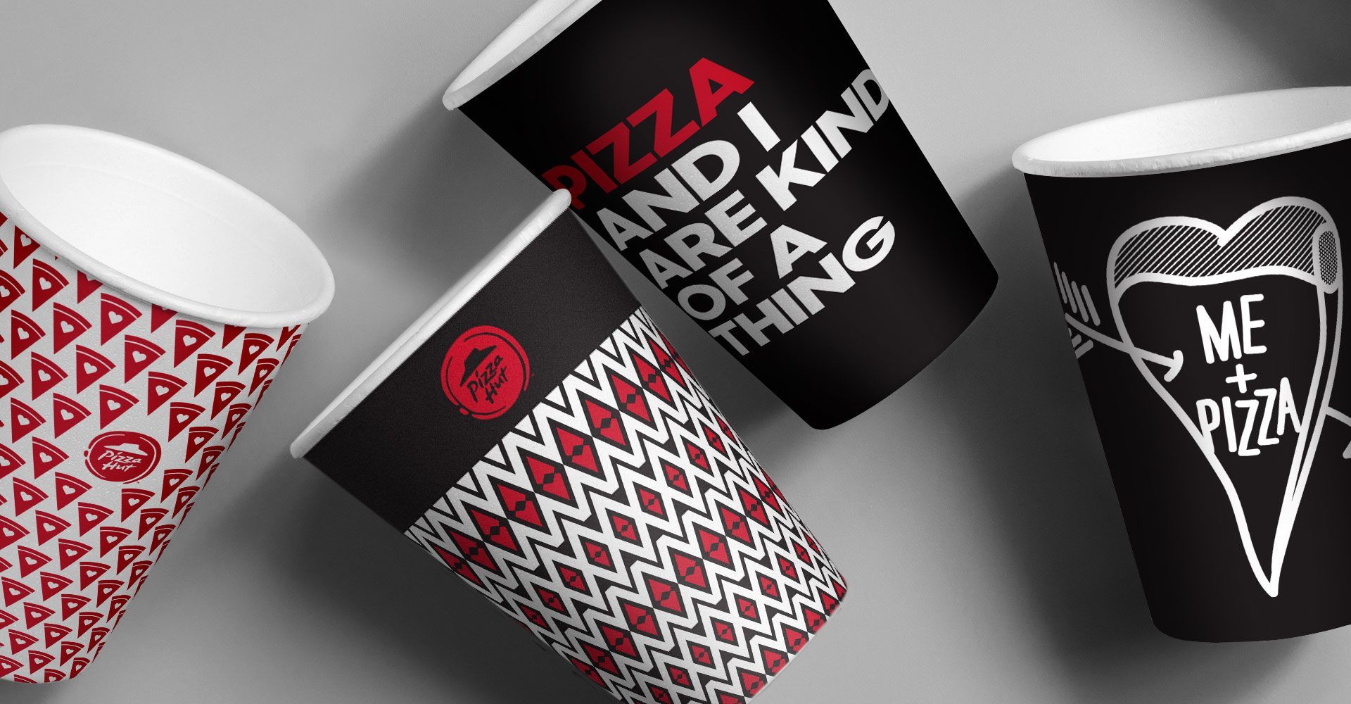 Three paper cups with different designs on them are sitting on a table.