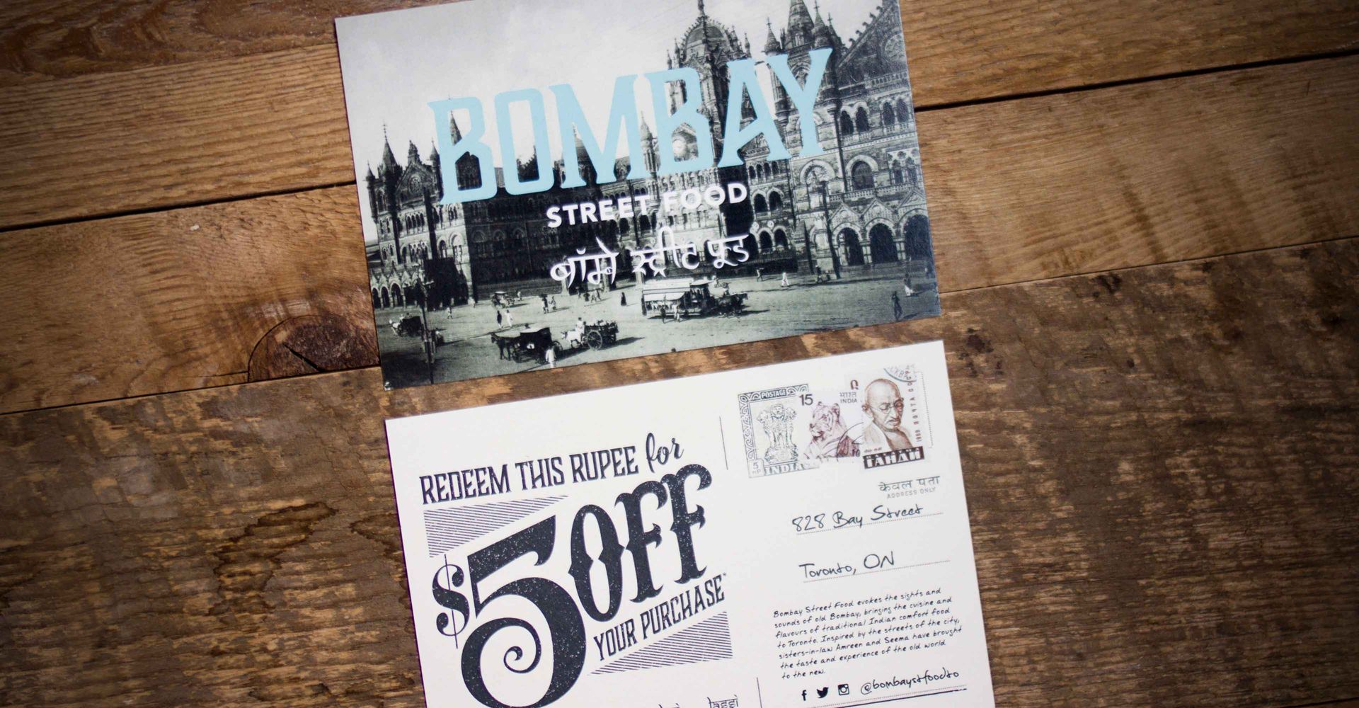 Two coupons on a wooden table one of which says $ 5 off