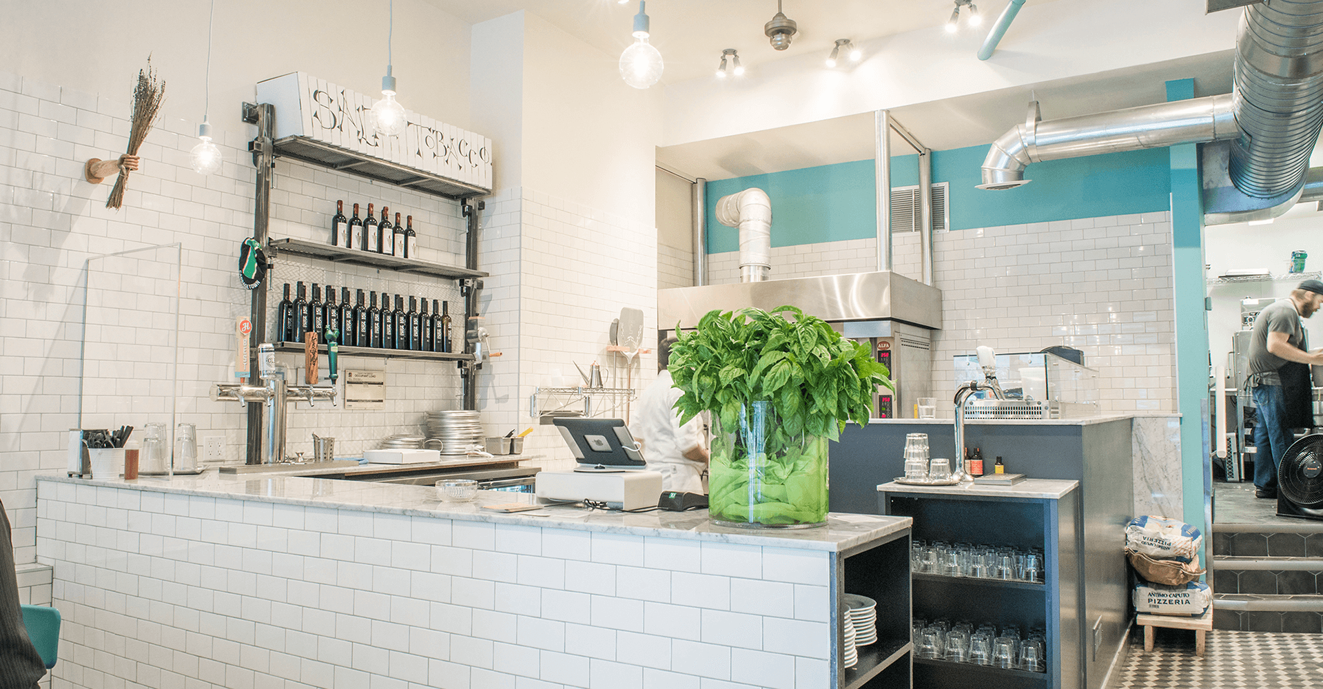 A restaurant with a white counter and a green plant on it.