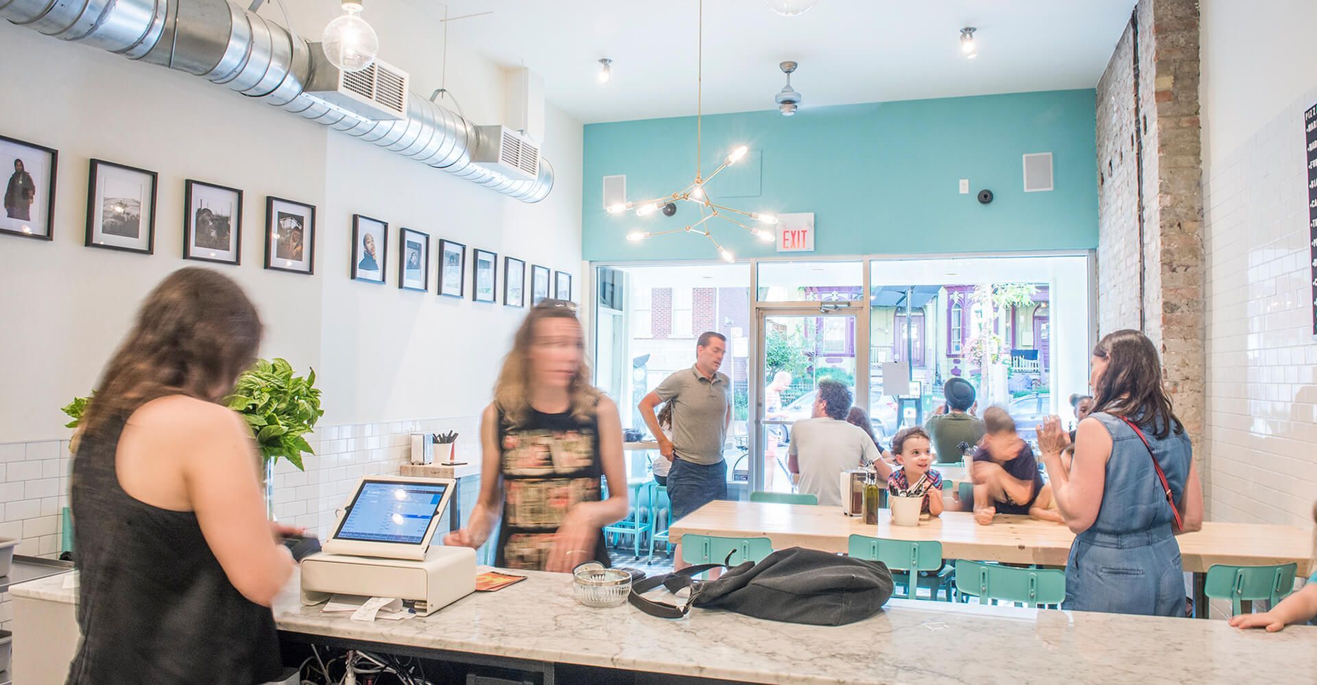 A group of people are sitting at tables in a restaurant.