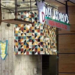 A sign for dal moro 's fresh pasta to go hangs from the ceiling