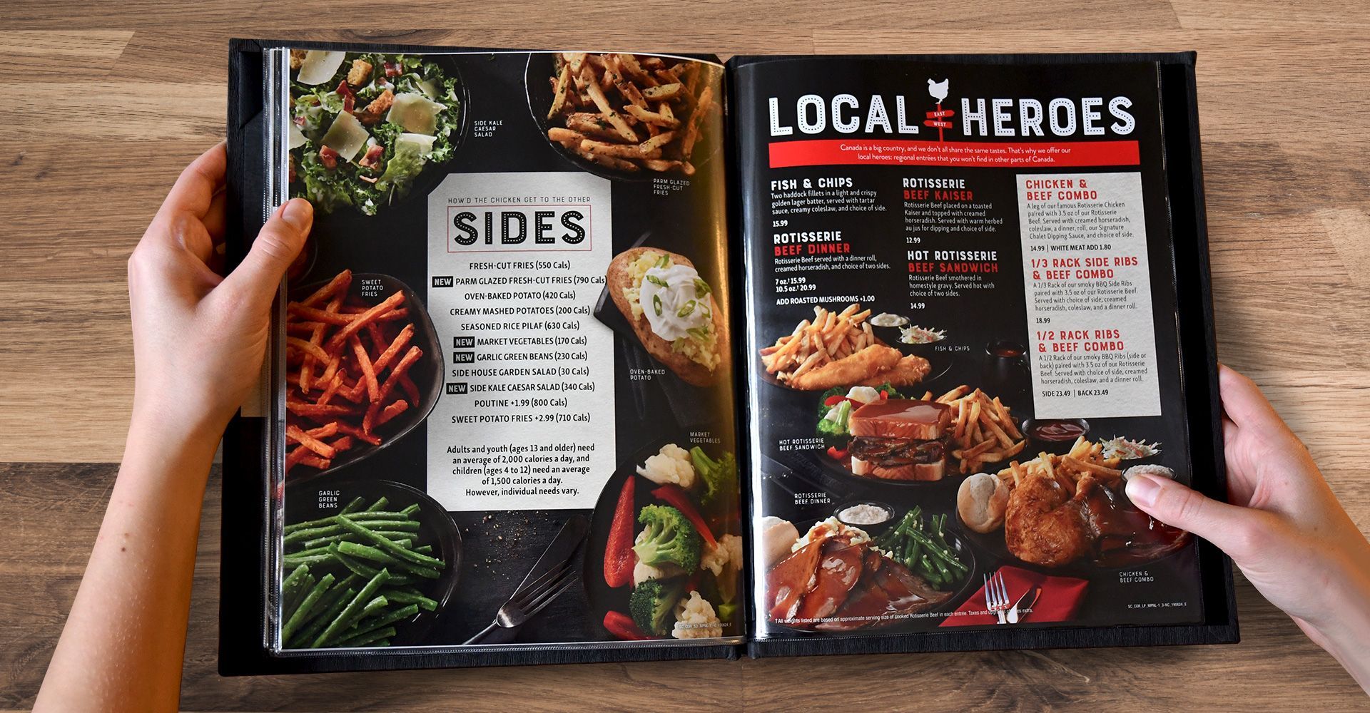 A person is holding a menu that says local heroes on it