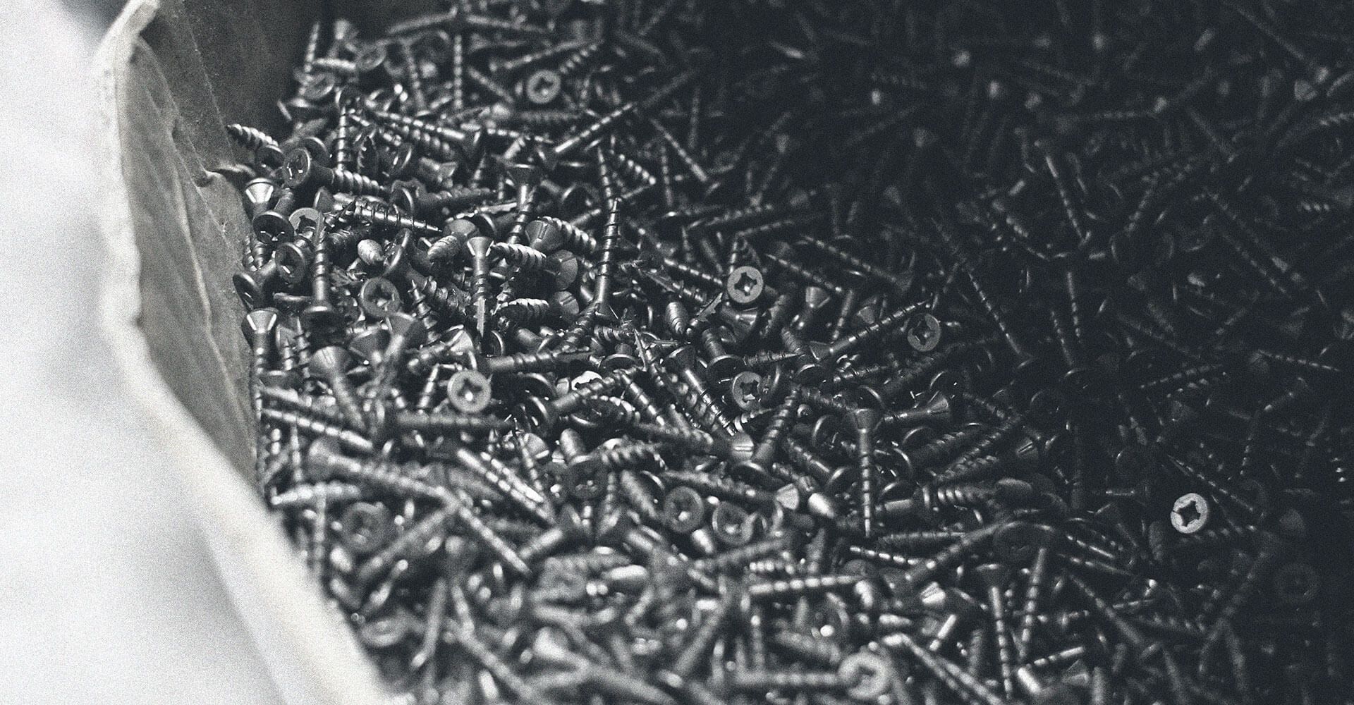 A black and white photo of a pile of screws