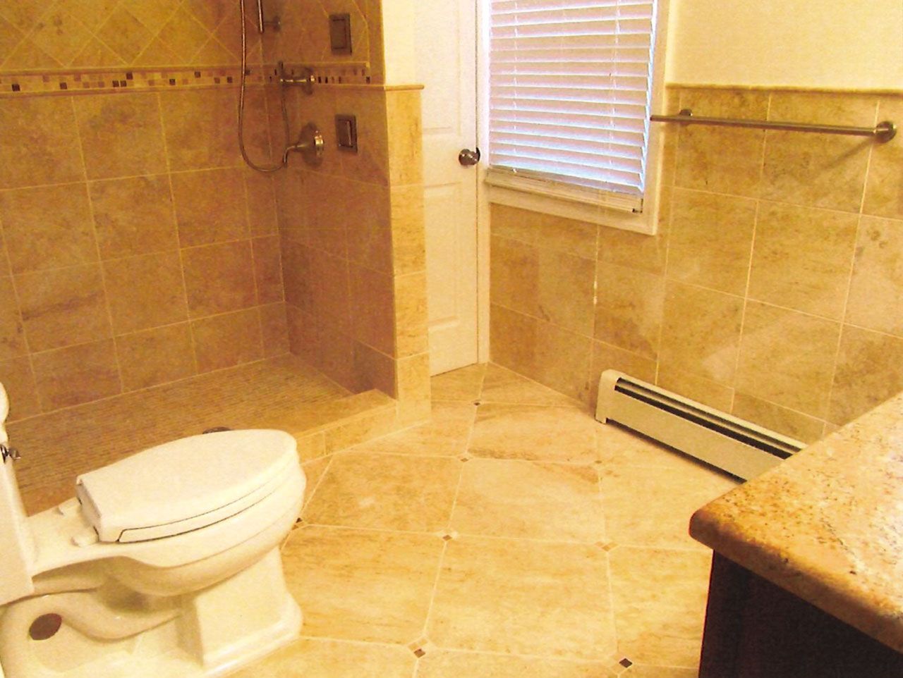 Bathroom with tan tile walls and floor; includes a toilet, shower, door, and a small window.
