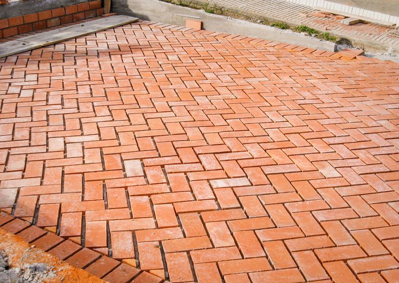 Herringbone brick patio, red-orange bricks, newly laid.