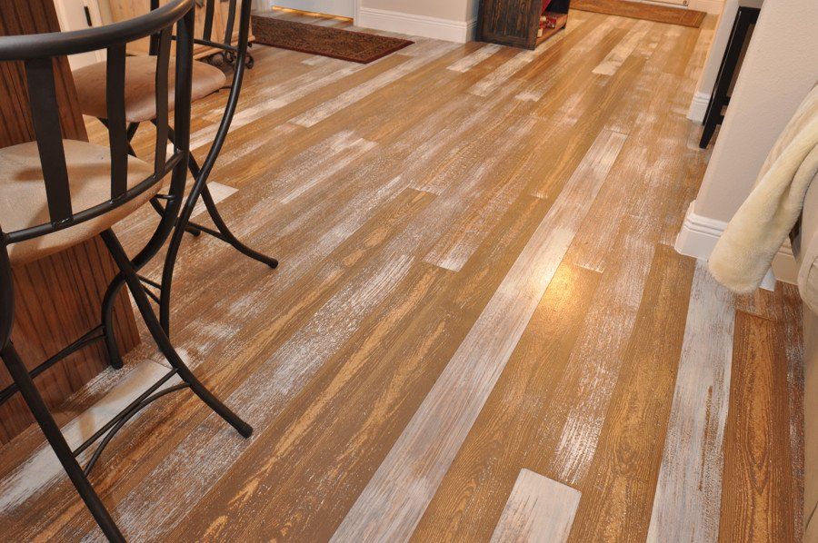 A kitchen with a wooden floor and a table and chairs.