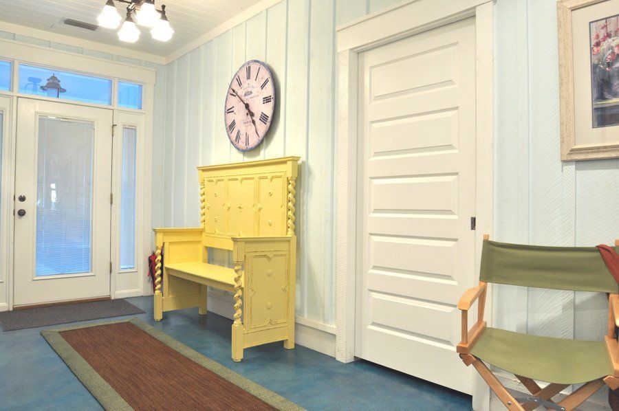 A hallway with a yellow bench and a clock on the wall