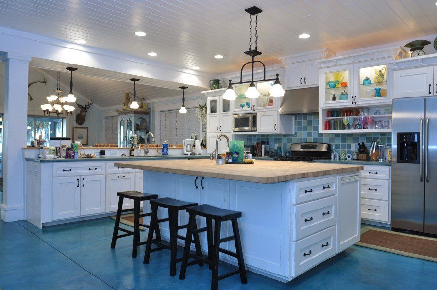 A kitchen with white cabinets and a large island
