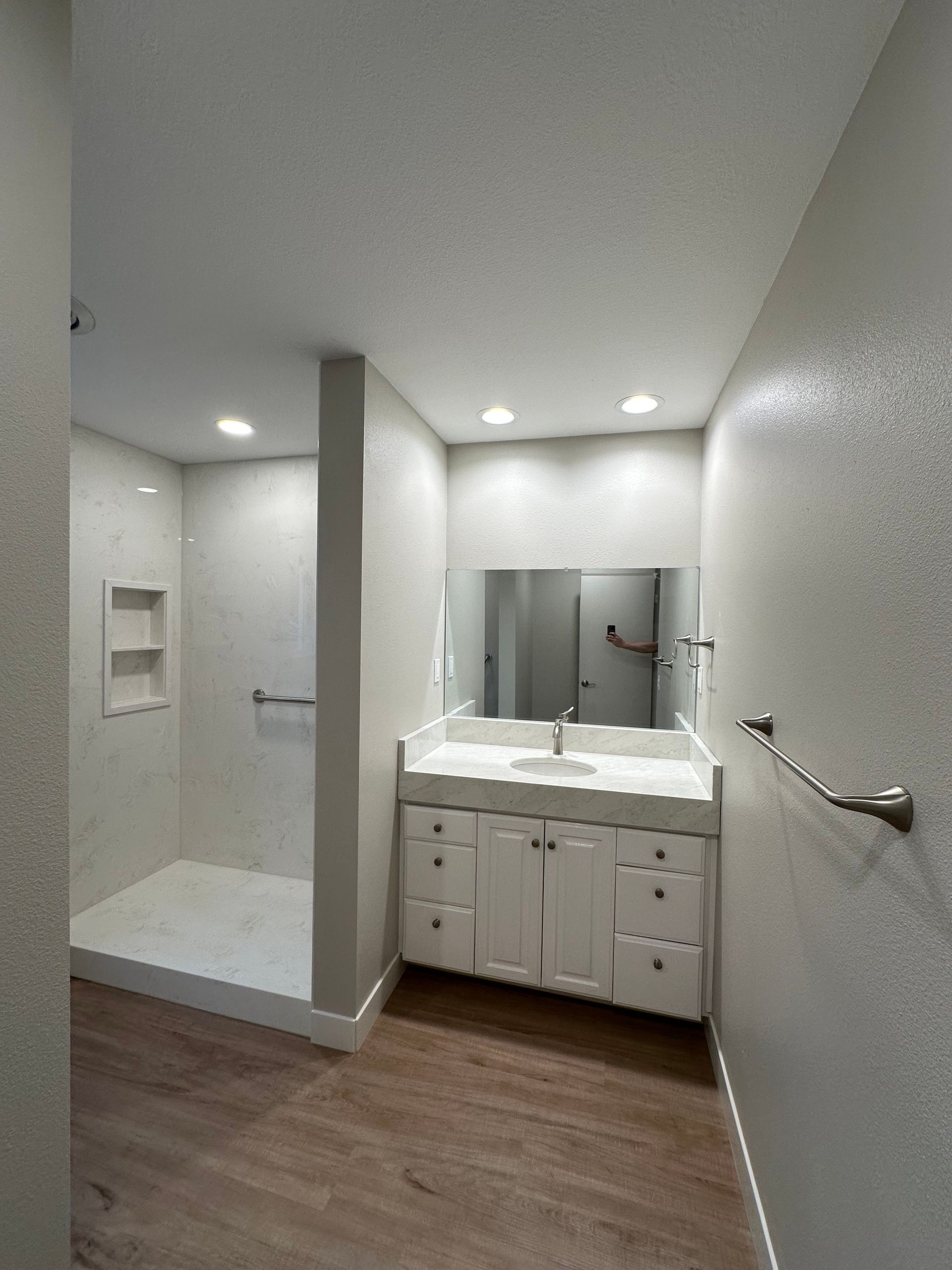 A bathroom with a sink and a walk in shower