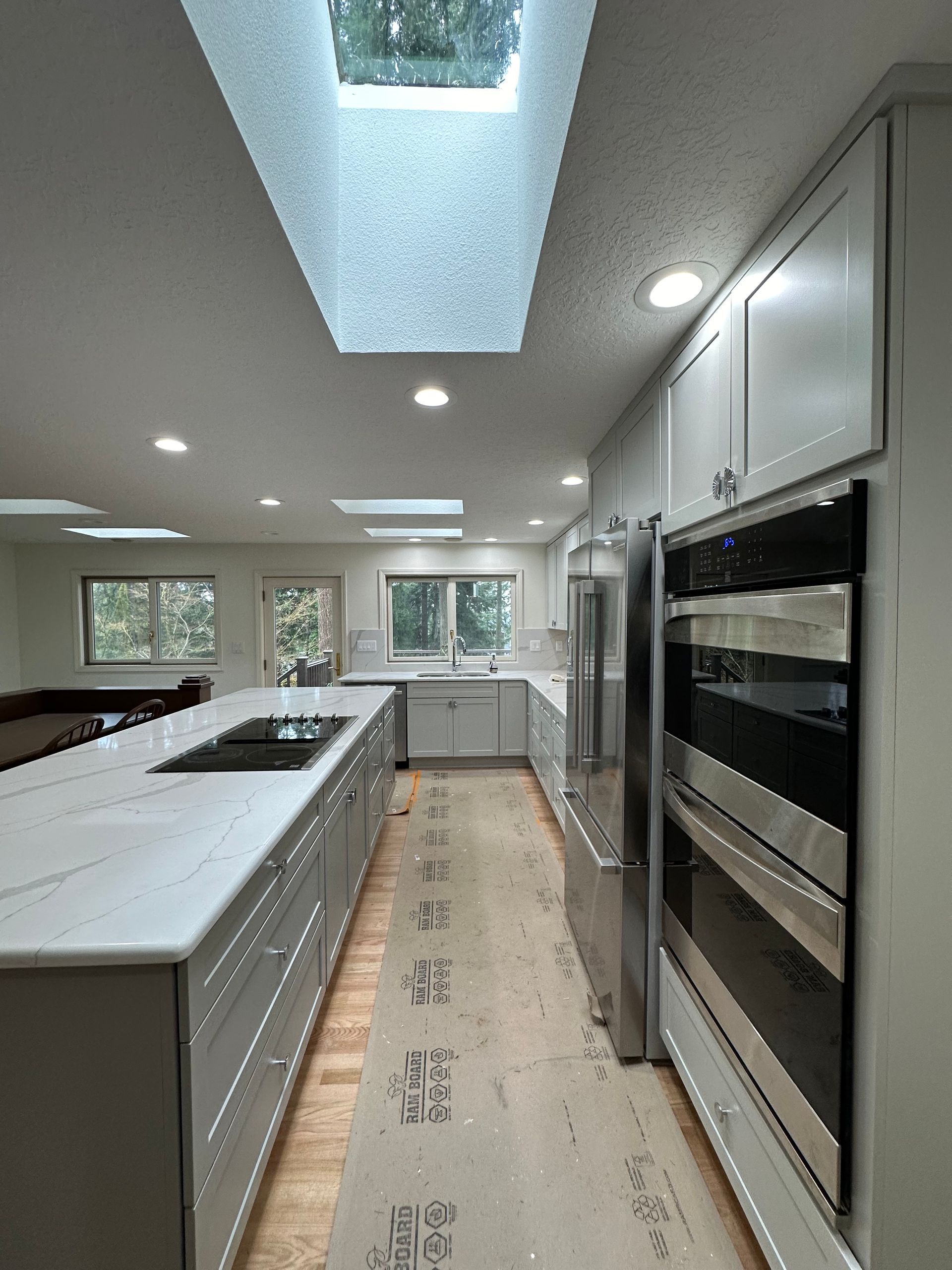 A kitchen with stainless steel appliances and a skylight in the ceiling.
