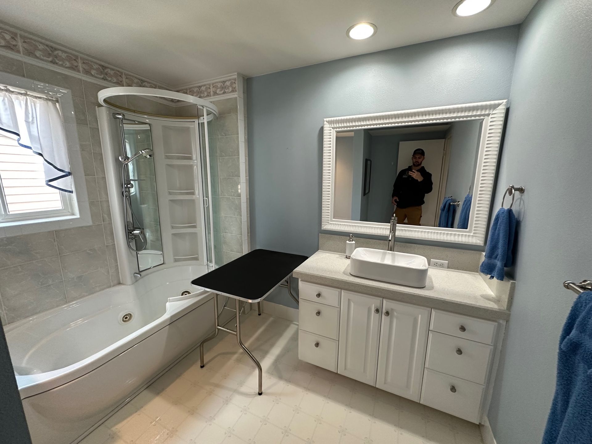 A bathroom with a tub , sink , and mirror.